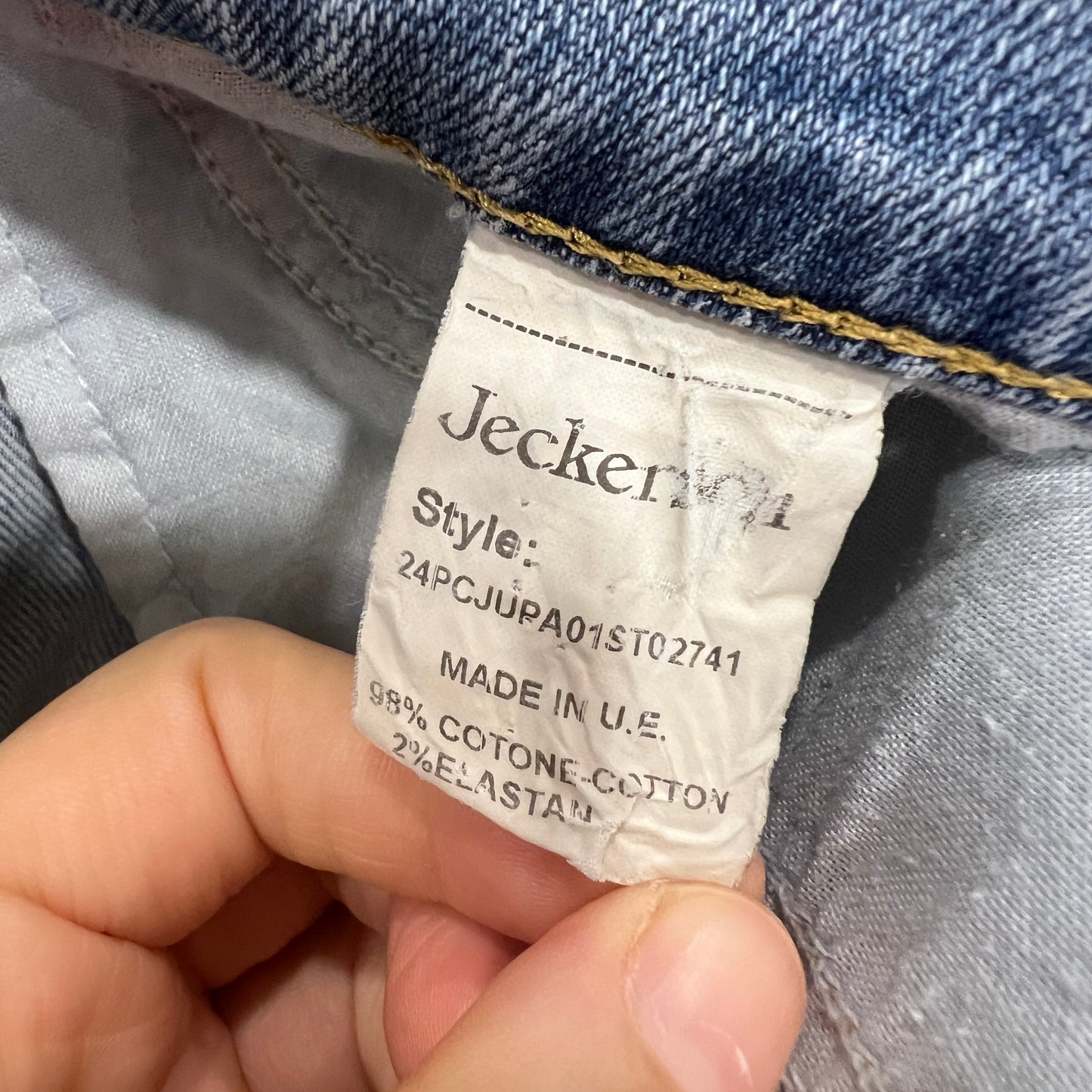 Jeckerson label on a denim garment held by a hand