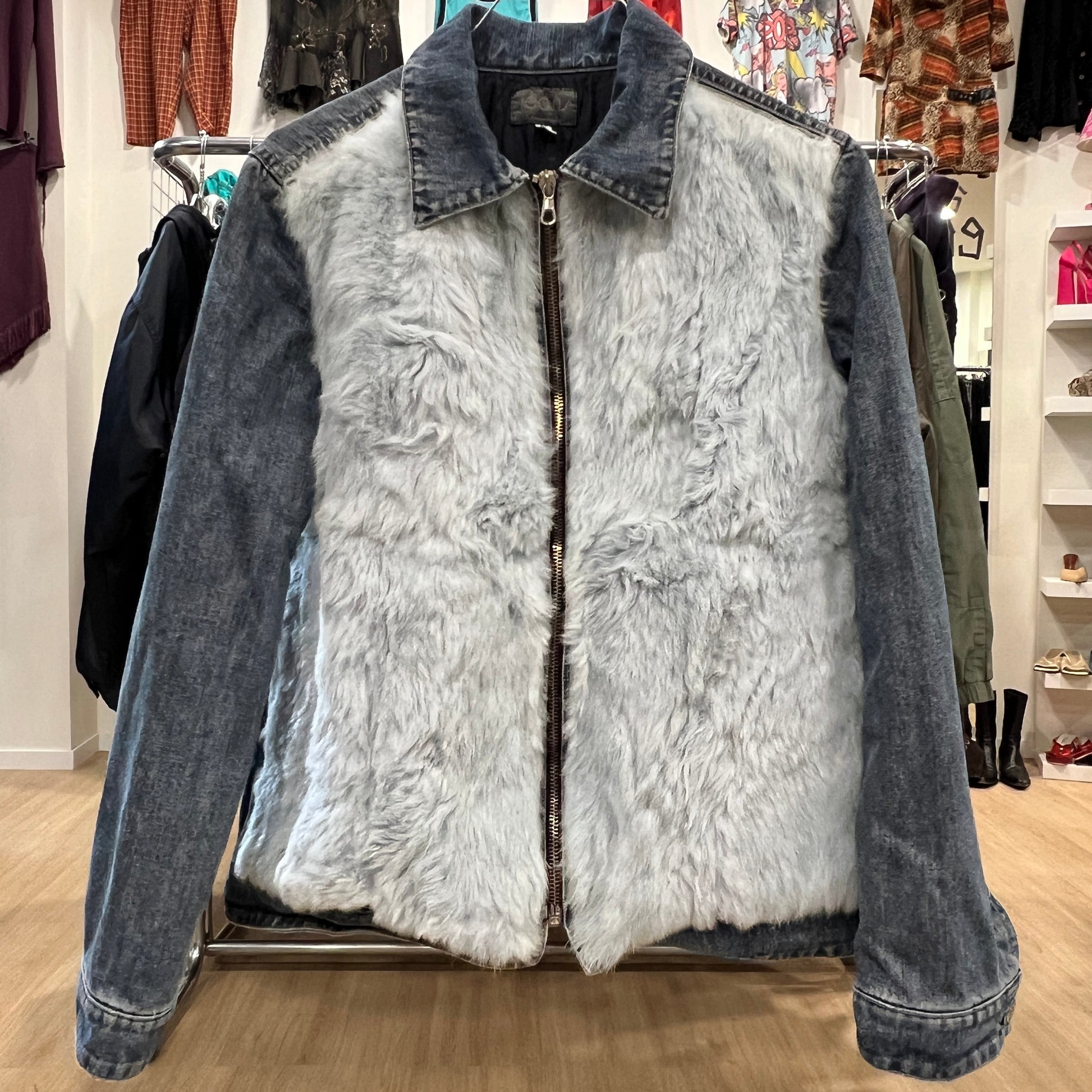 Denim jacket with fur lining on a rack in a store setting