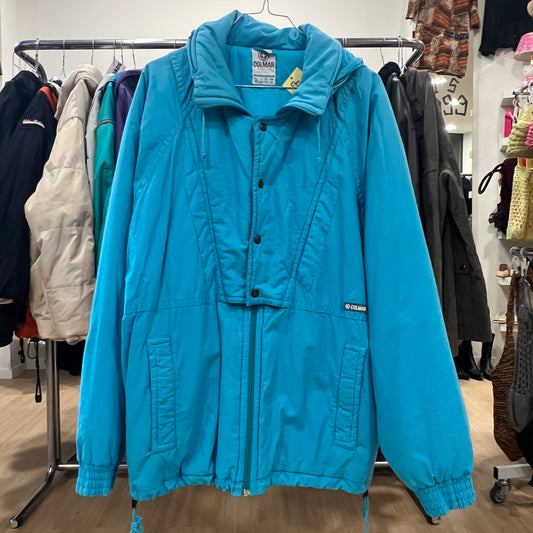 Blue puffer jacket hanging on a rack in a store setting