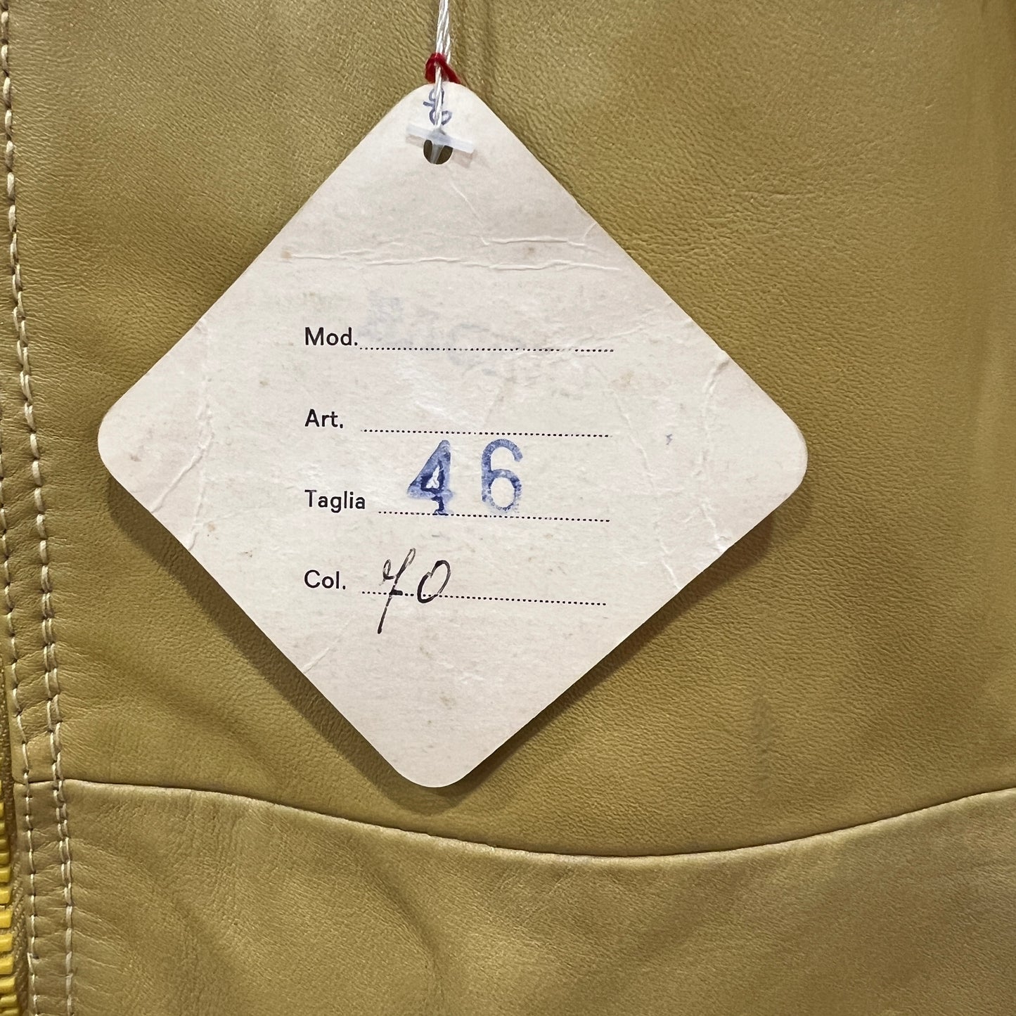 Clothing tag on a beige jacket with size and color information