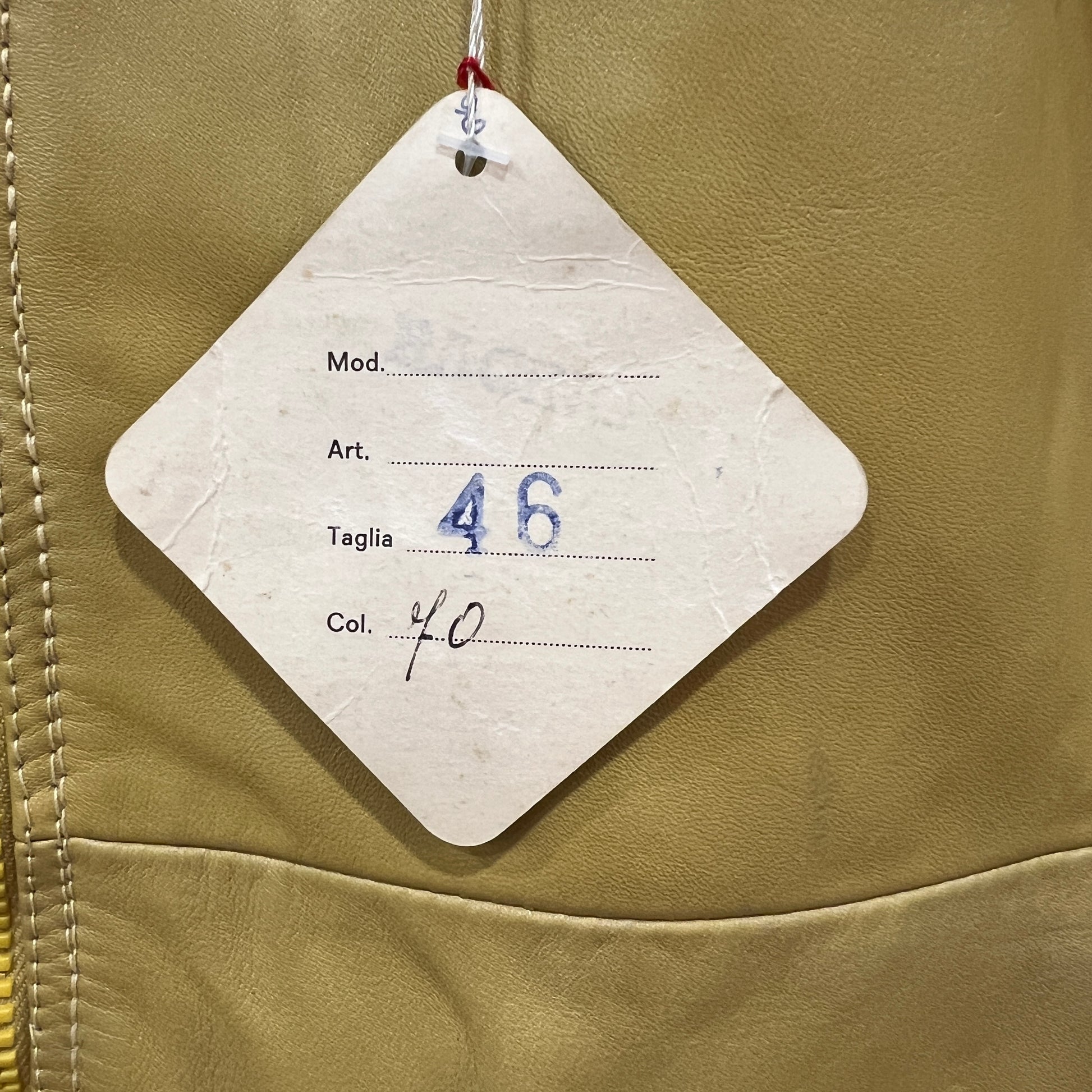 Clothing tag on a beige jacket with size and color information