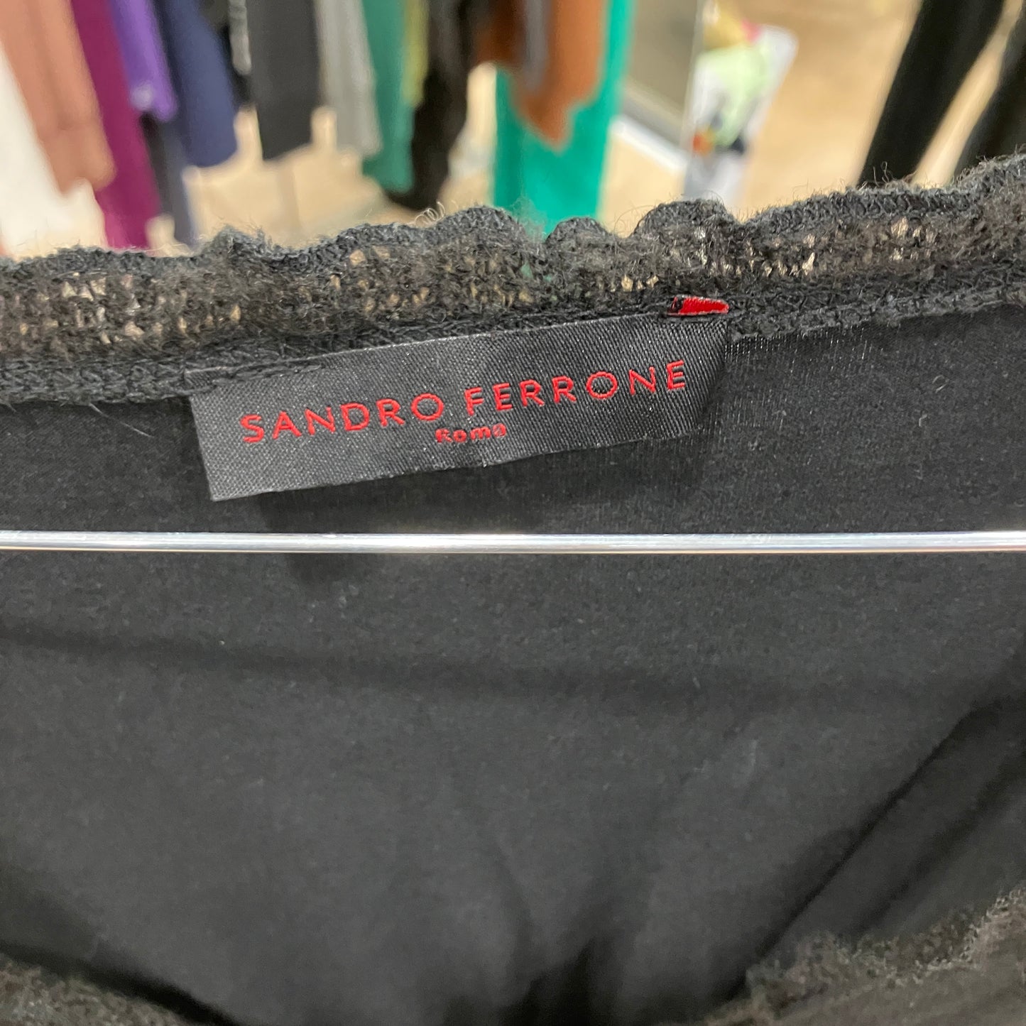 Close-up of a Sandro Ferrone label on a garment with a blurred background