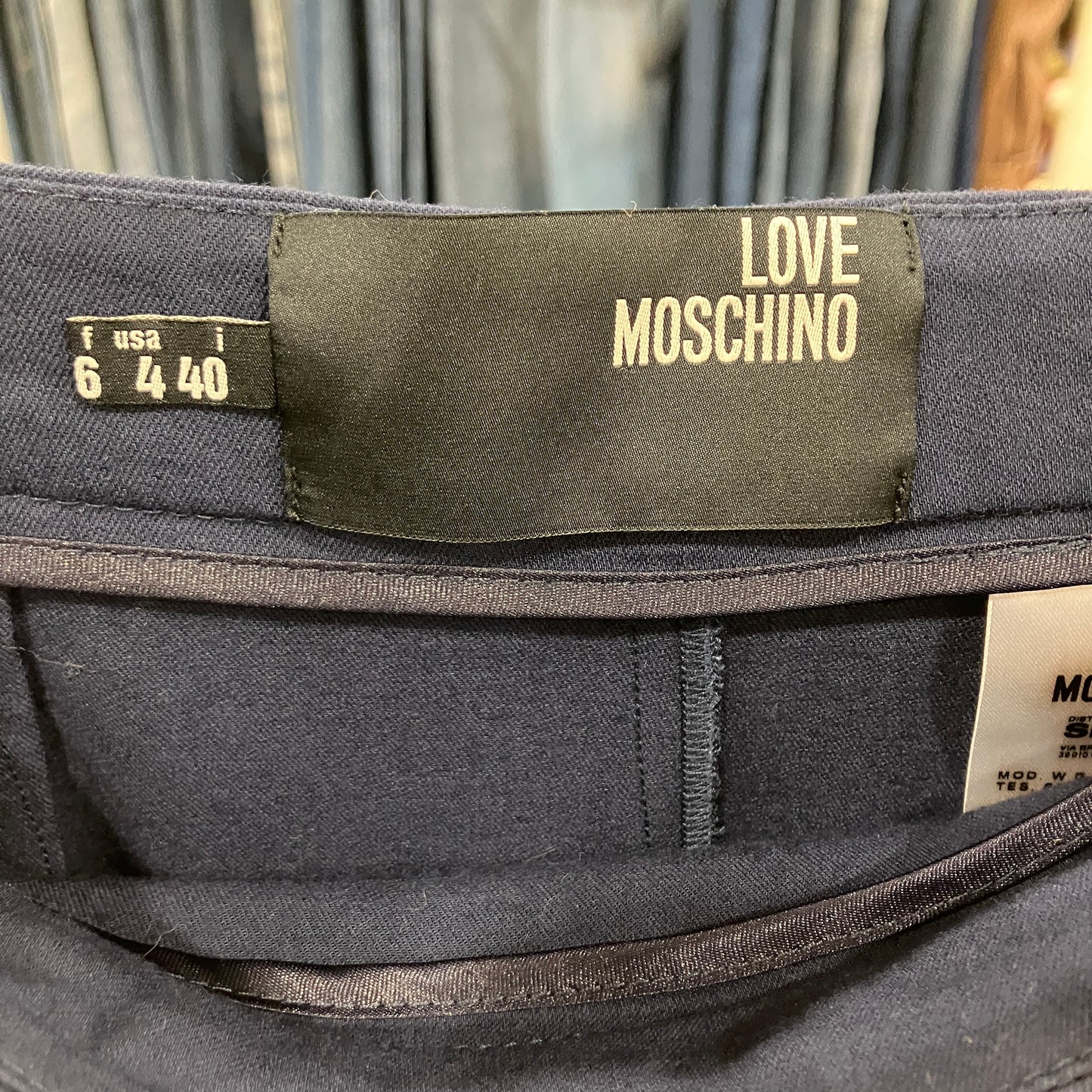Navy Blue pants with a Love Moschino label on a blurred background