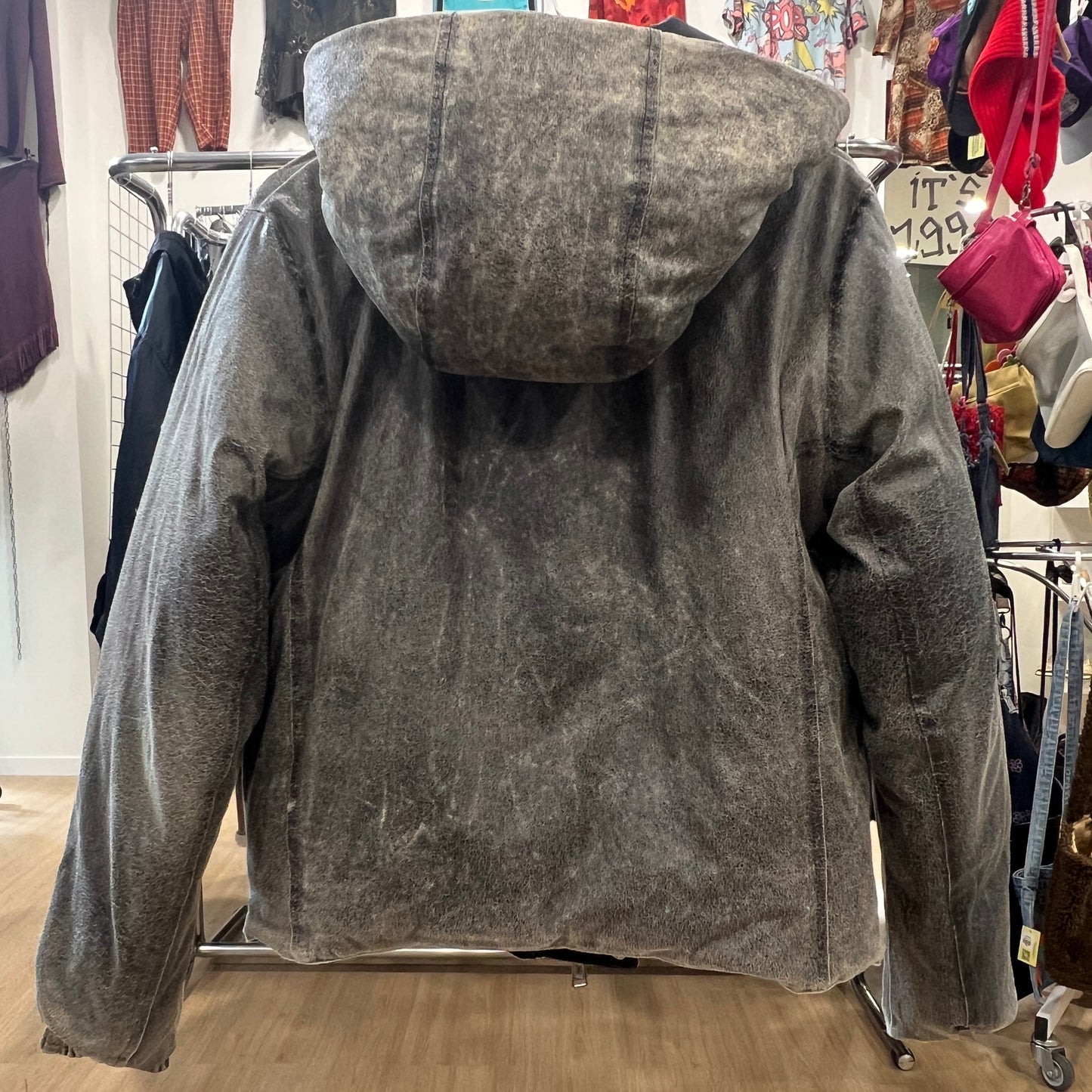 Gray hooded jacket on a rack in a store setting