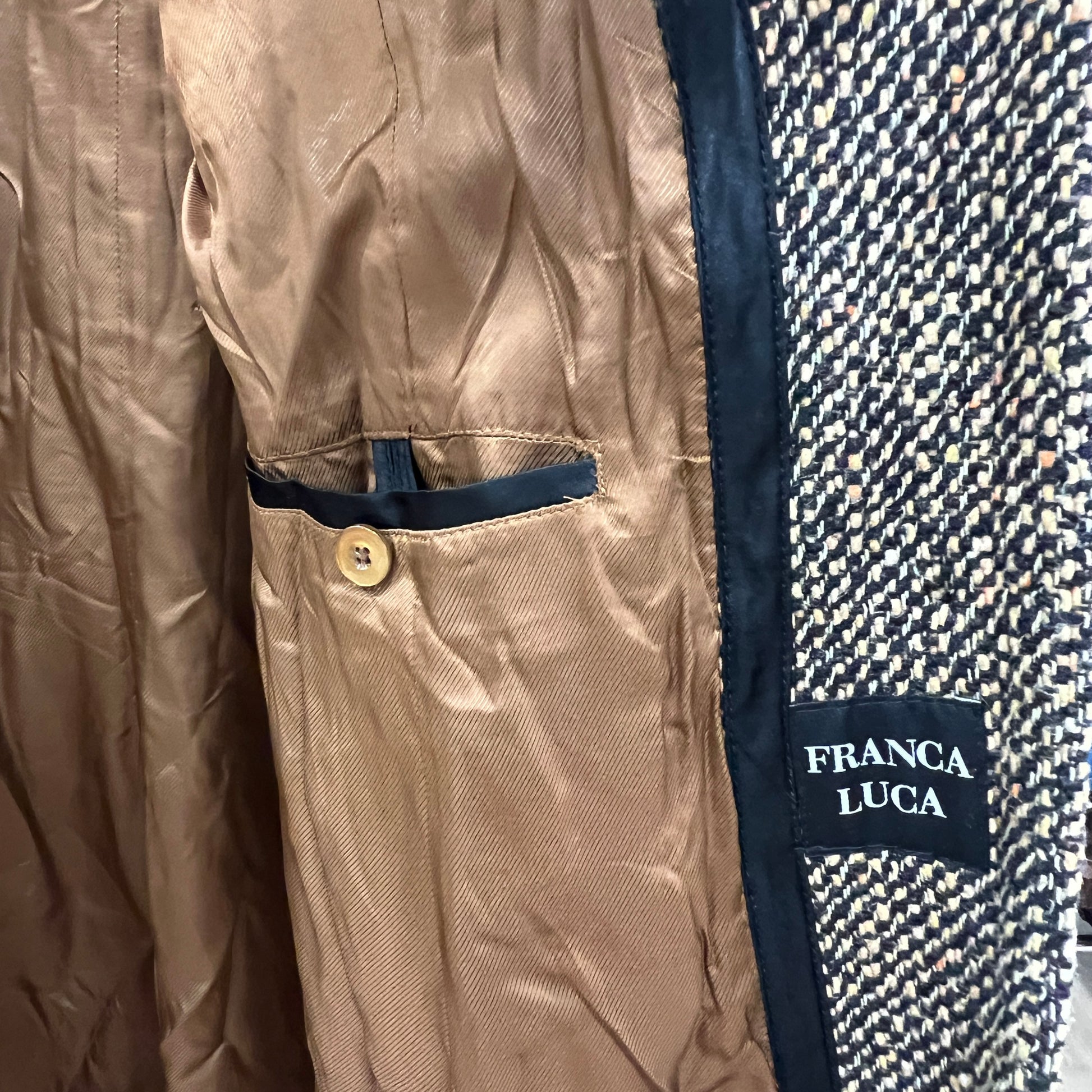 Close-up of a beige jacket with navy lining and 'Franca Luca' label