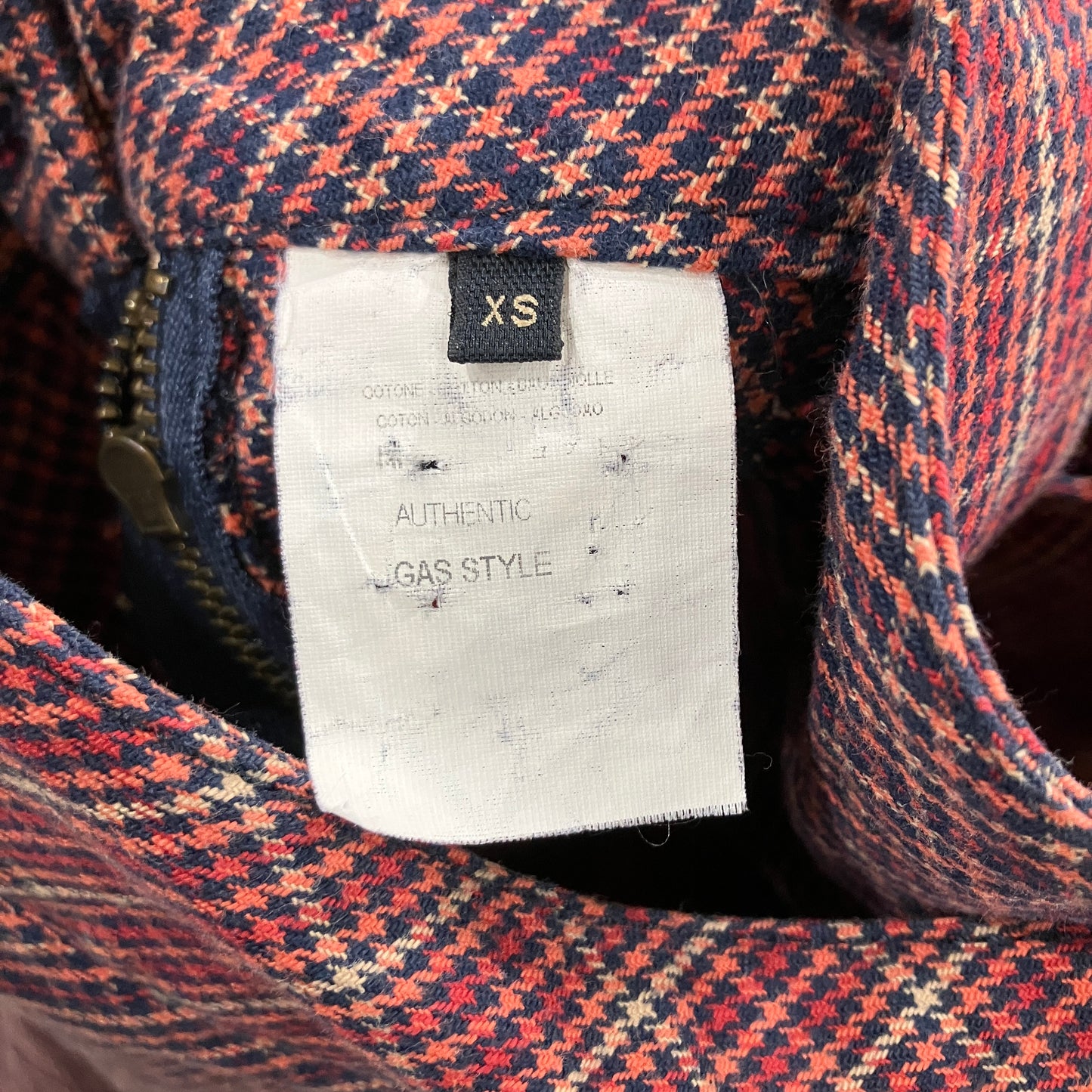 Close-up of a plaid garment with a size label and 'GAS STYLE' branding