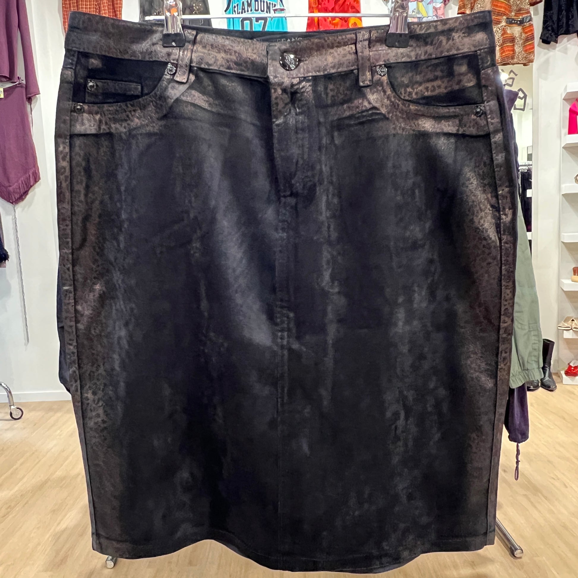 Black acid-wash denim skirt on a hanger in a store setting