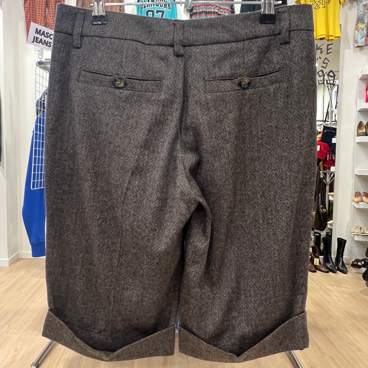 Gray shorts on a hanger in a store setting