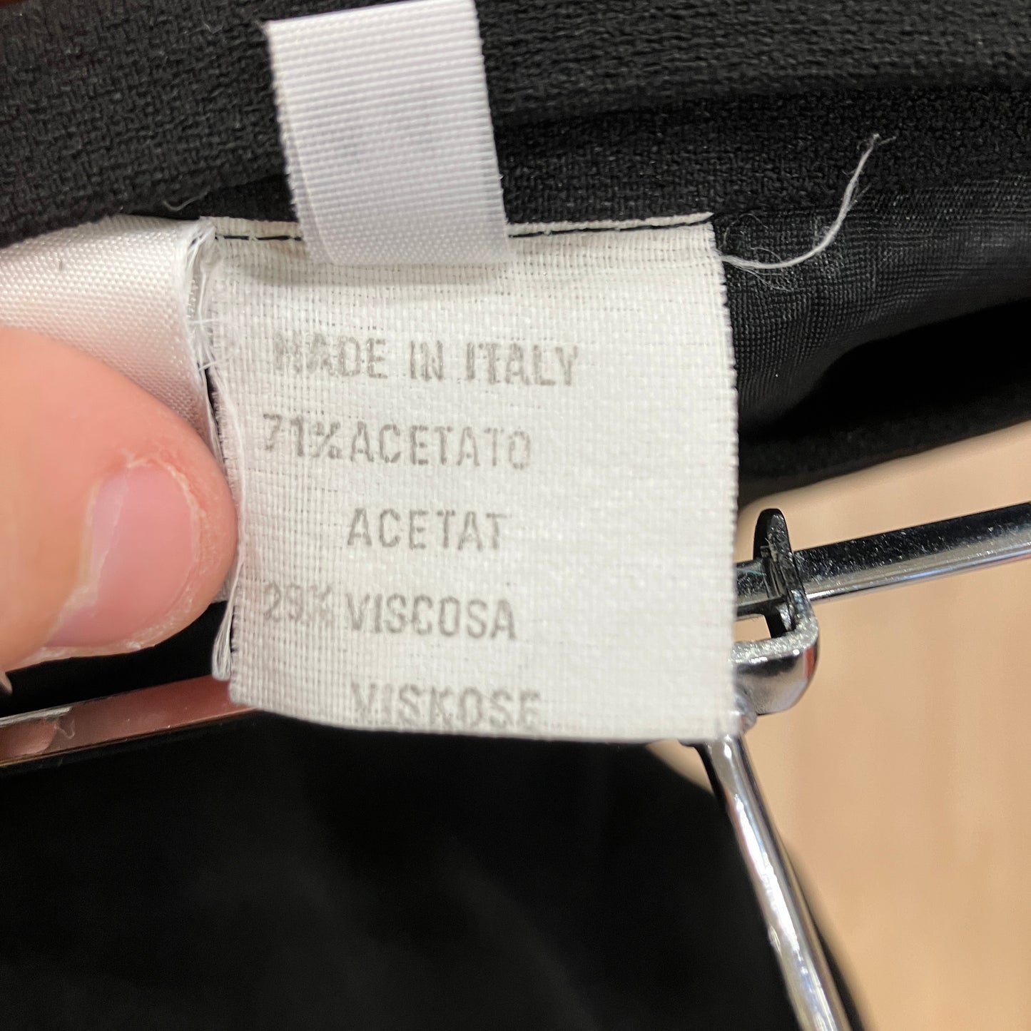 Fabric tag with material composition details held by a hand