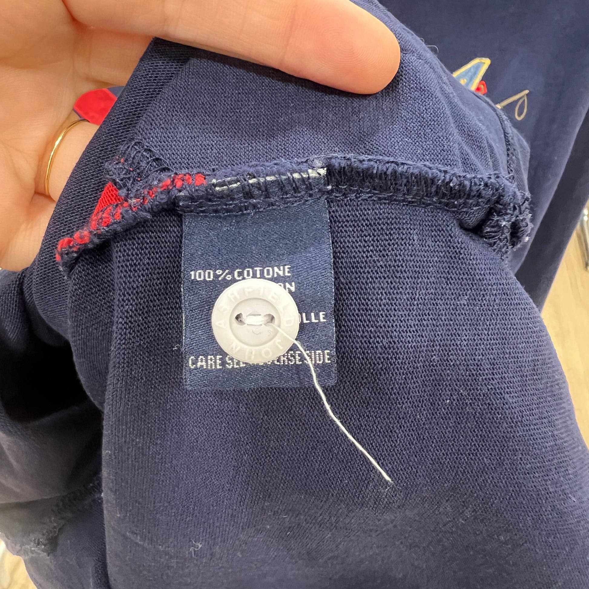 Navy blue fabric with a label on a person's hand