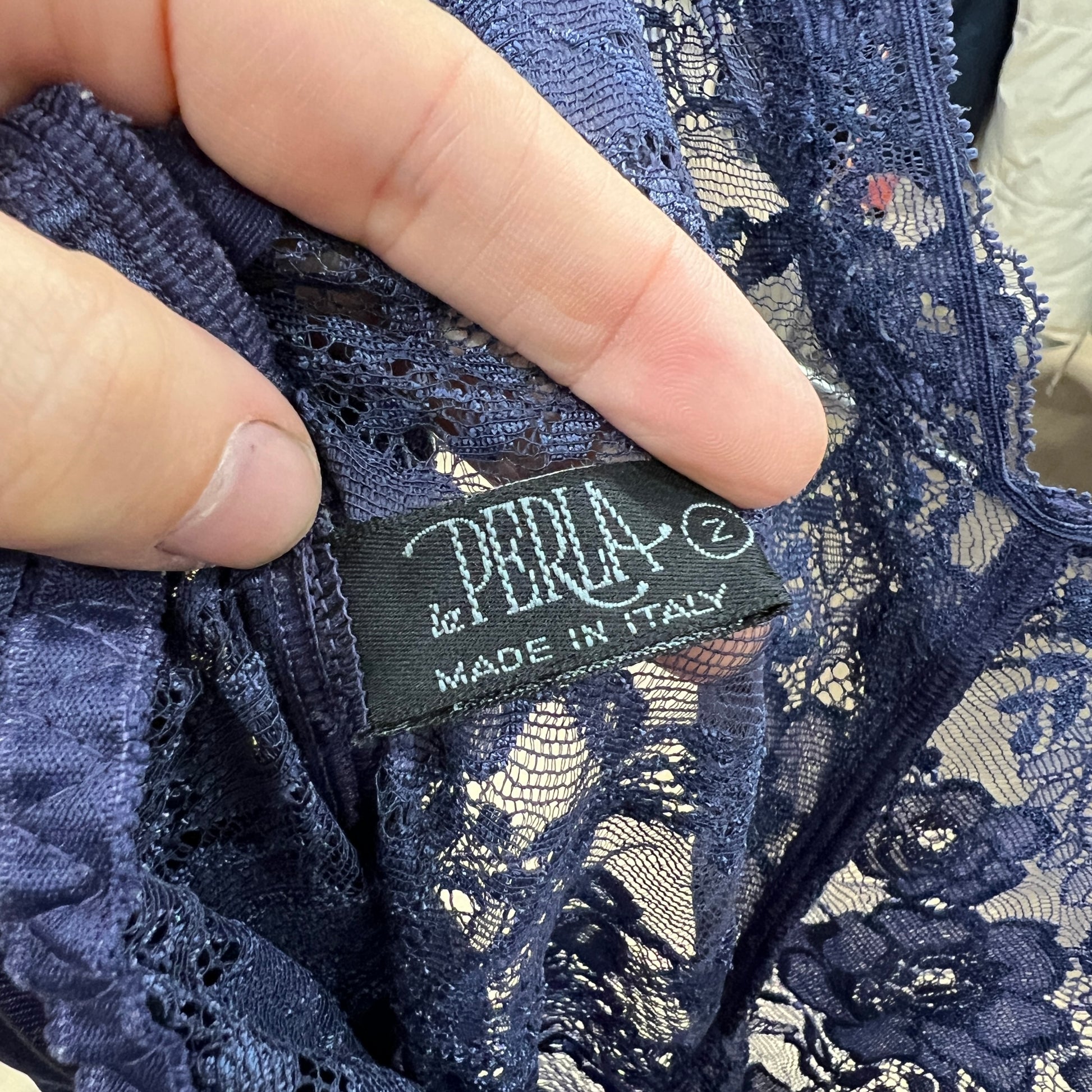 Navy lace fabric with a 'Le Perla' label indicating 'Made in Italy'