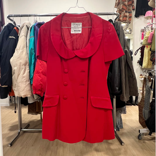 Red coat on a rack with other clothing in a store setting