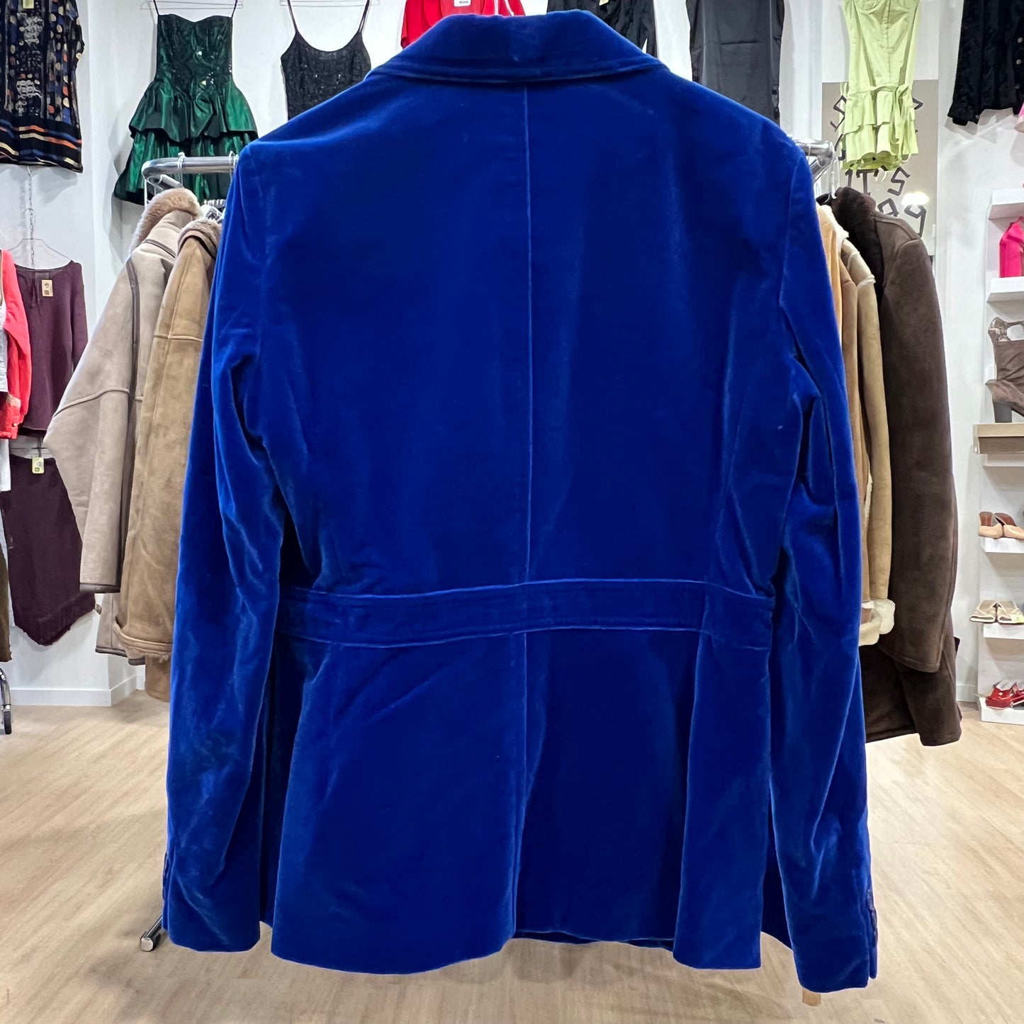 Blue jacket in a clothing store with various garments in the background