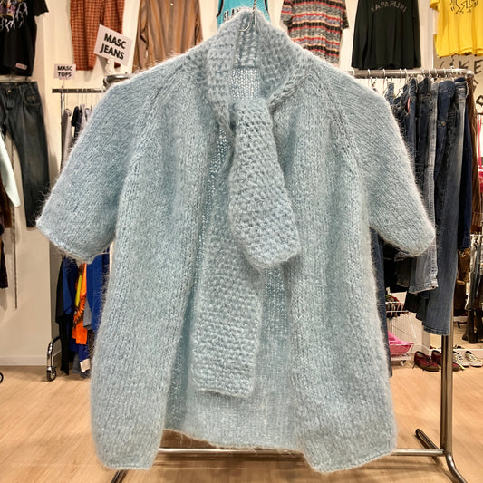 Light blue knitted cardigan on a hanger in a clothing store