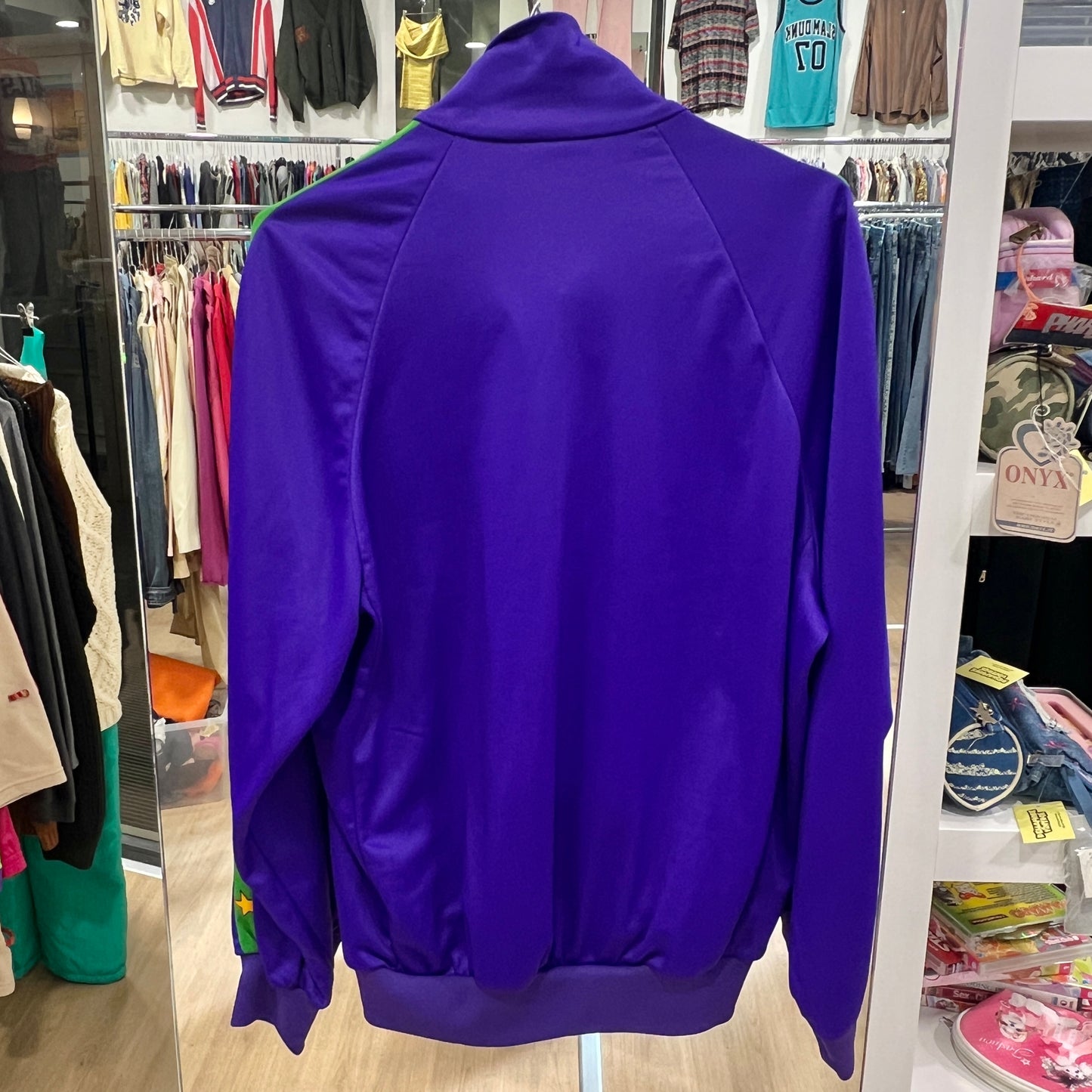 Purple jacket displayed in a store with clothing racks in the background