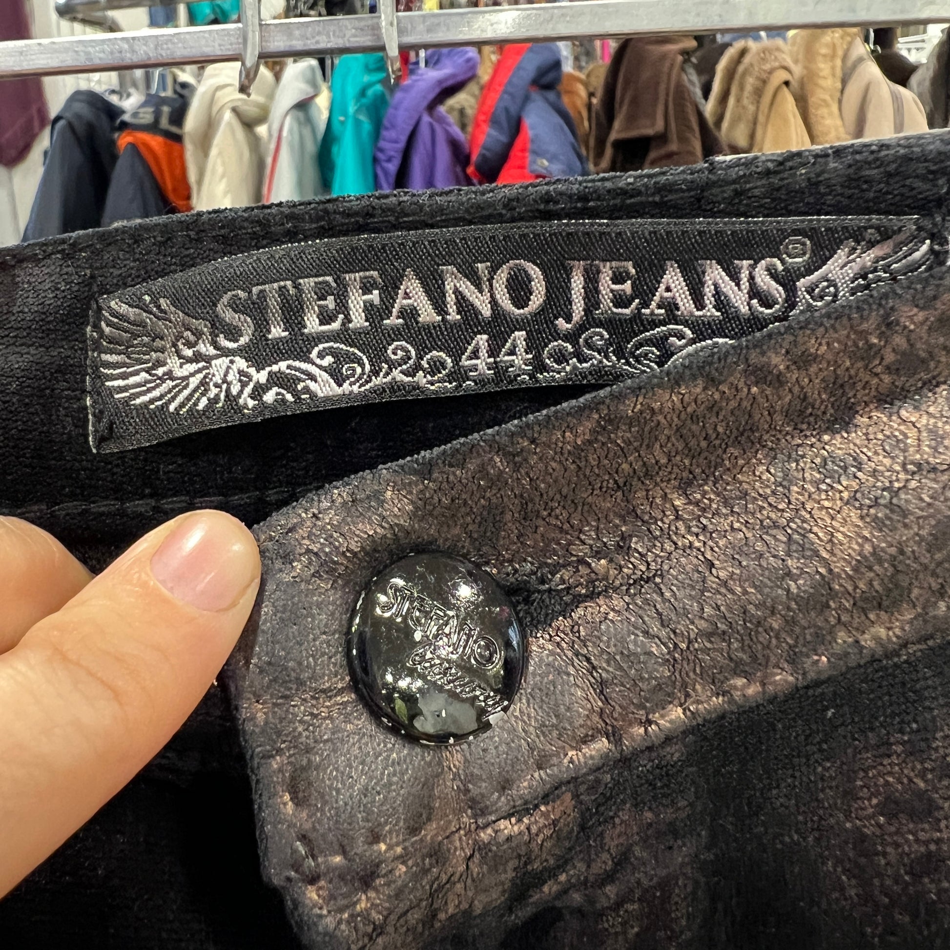 Close-up of a dark brown leather skirt with 'Stefano Jeans' label and button