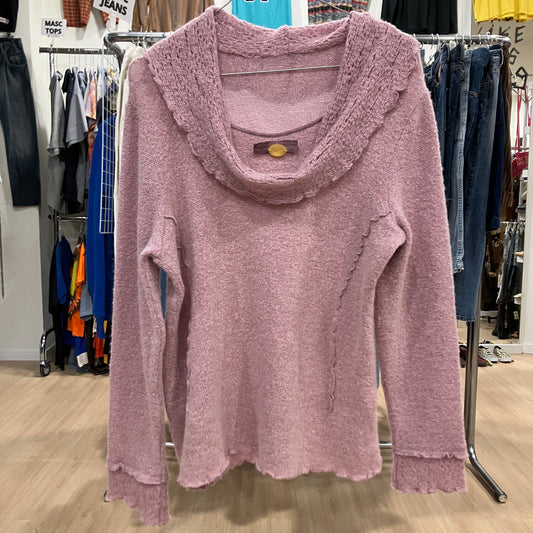 Pink sweater with a brand logo on a hanger in a clothing store