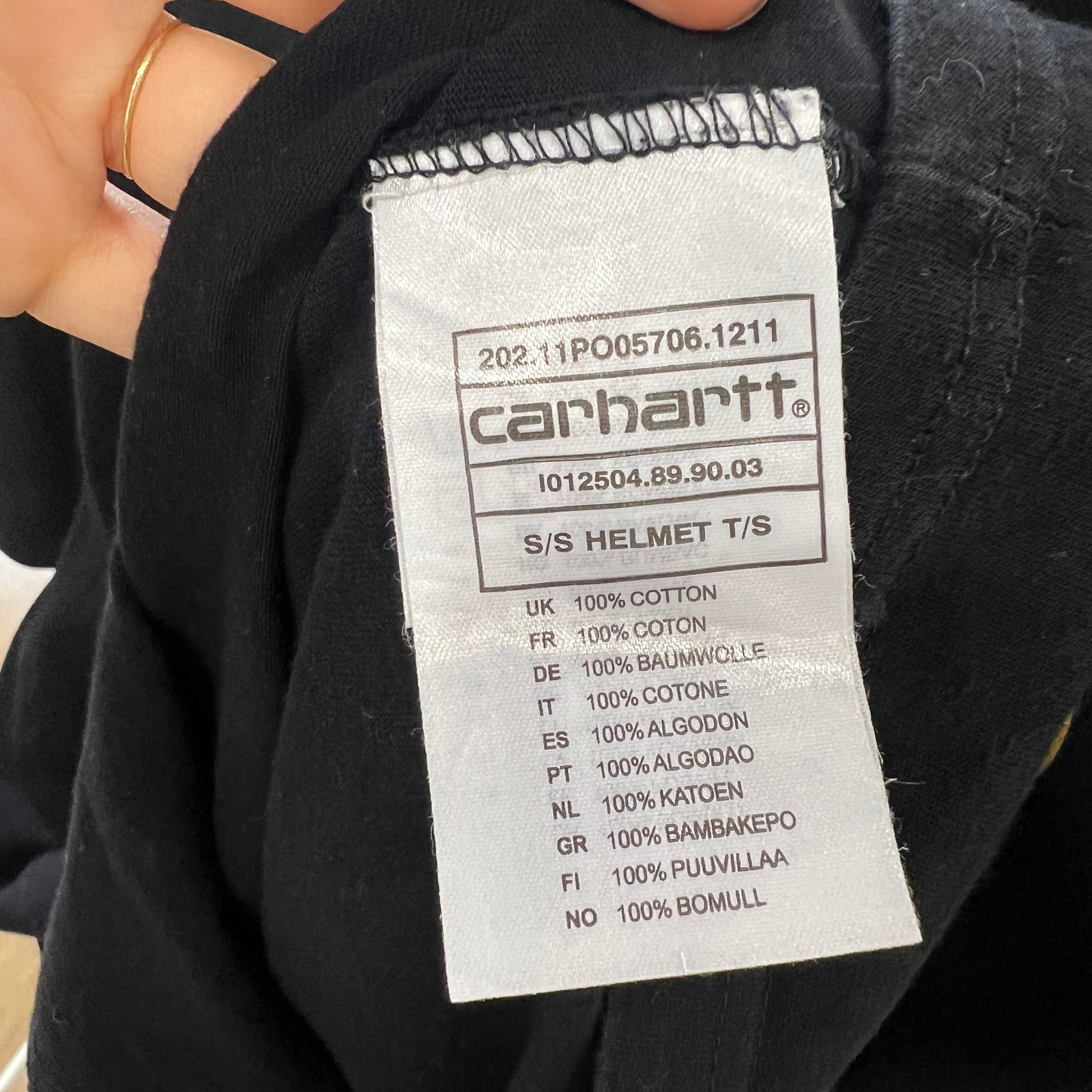 Carhartt label on a black garment with text details