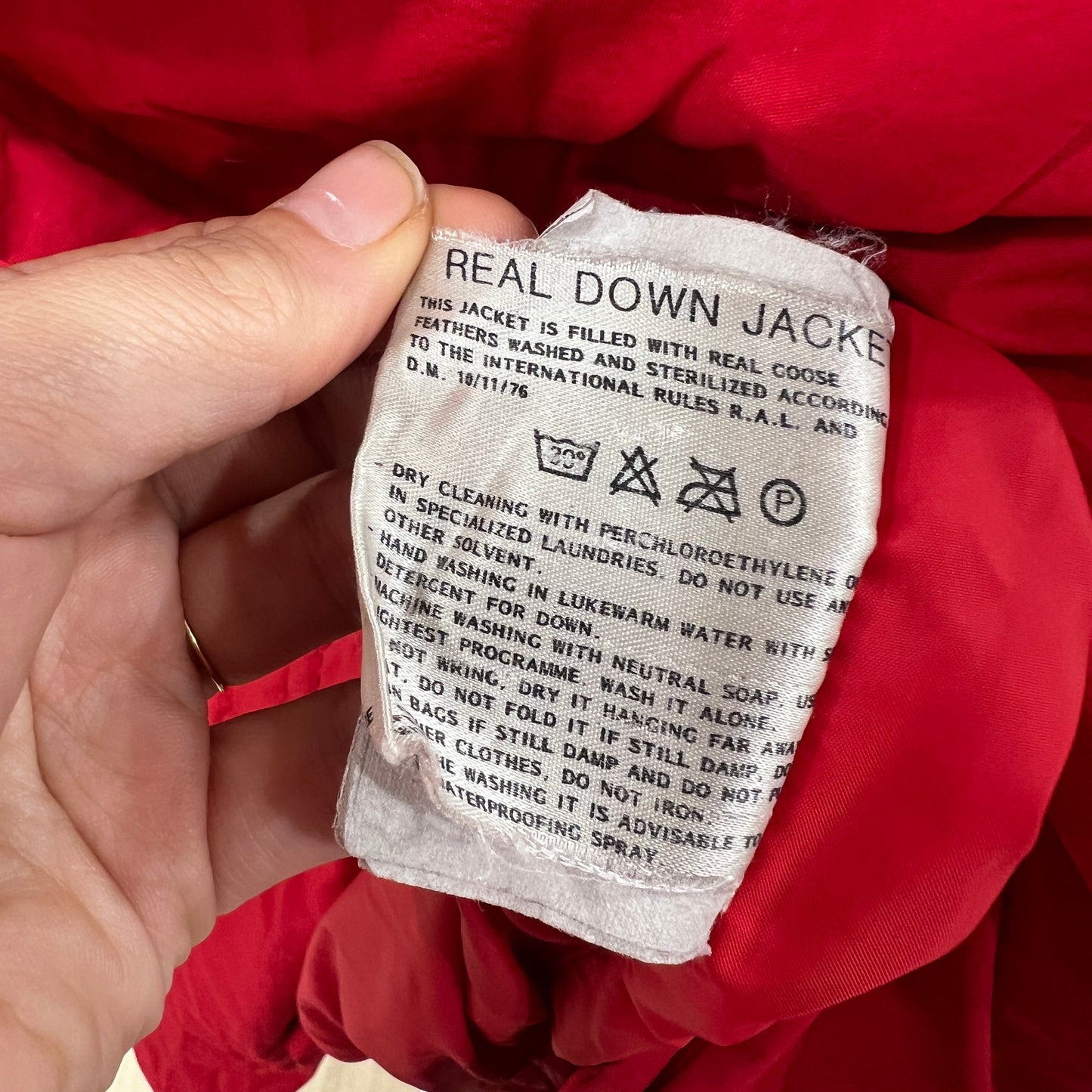 Label on a red jacket indicating 'Real Down Jacket' with care instructions
