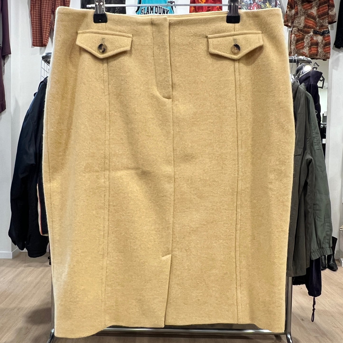 Beige skirt on a hanger in a store setting
