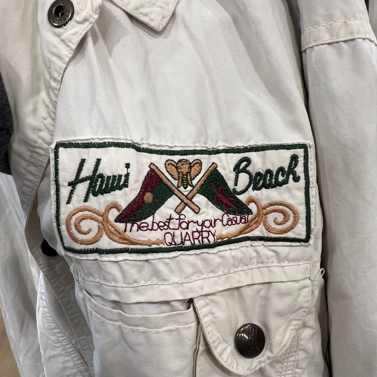 Embroidered patch on a light-colored jacket with text and graphics