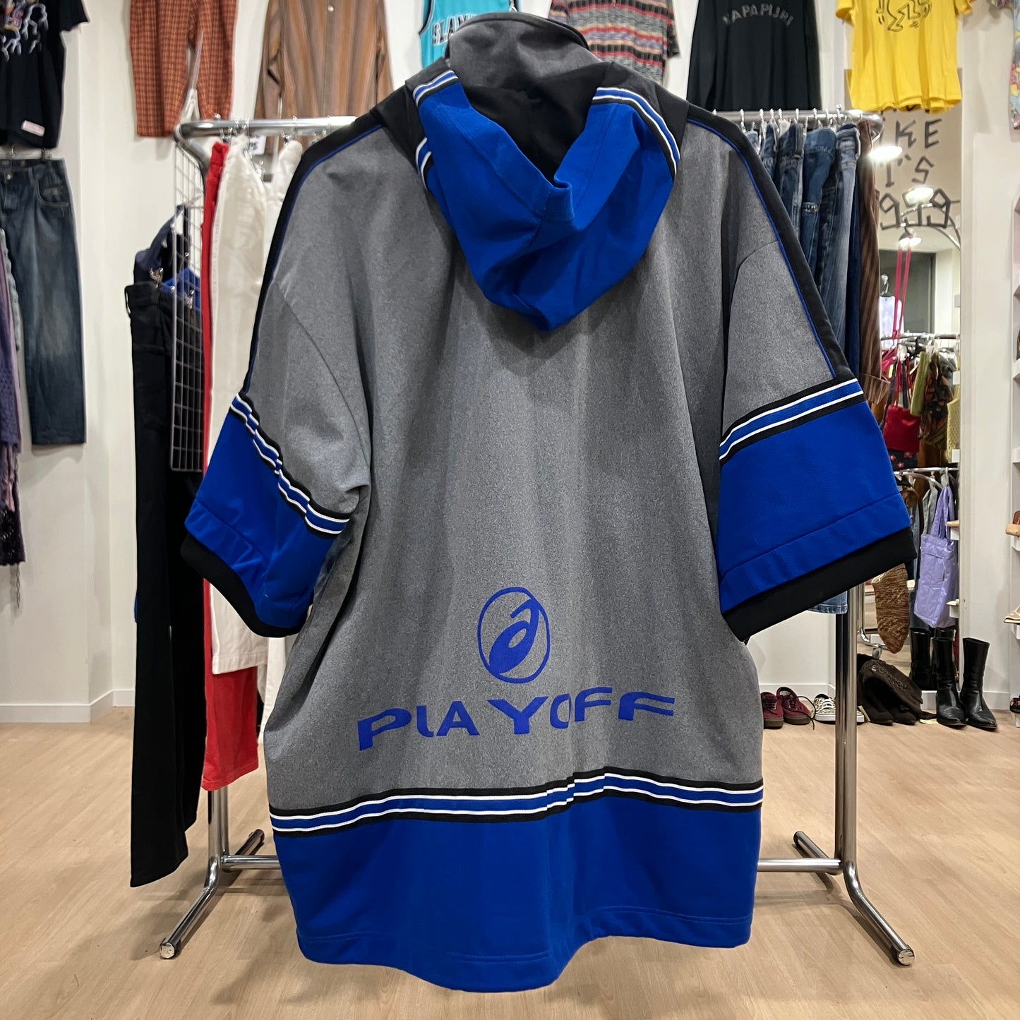 Gray and blue hoodie with 'Playoff' branding in a clothing store setting