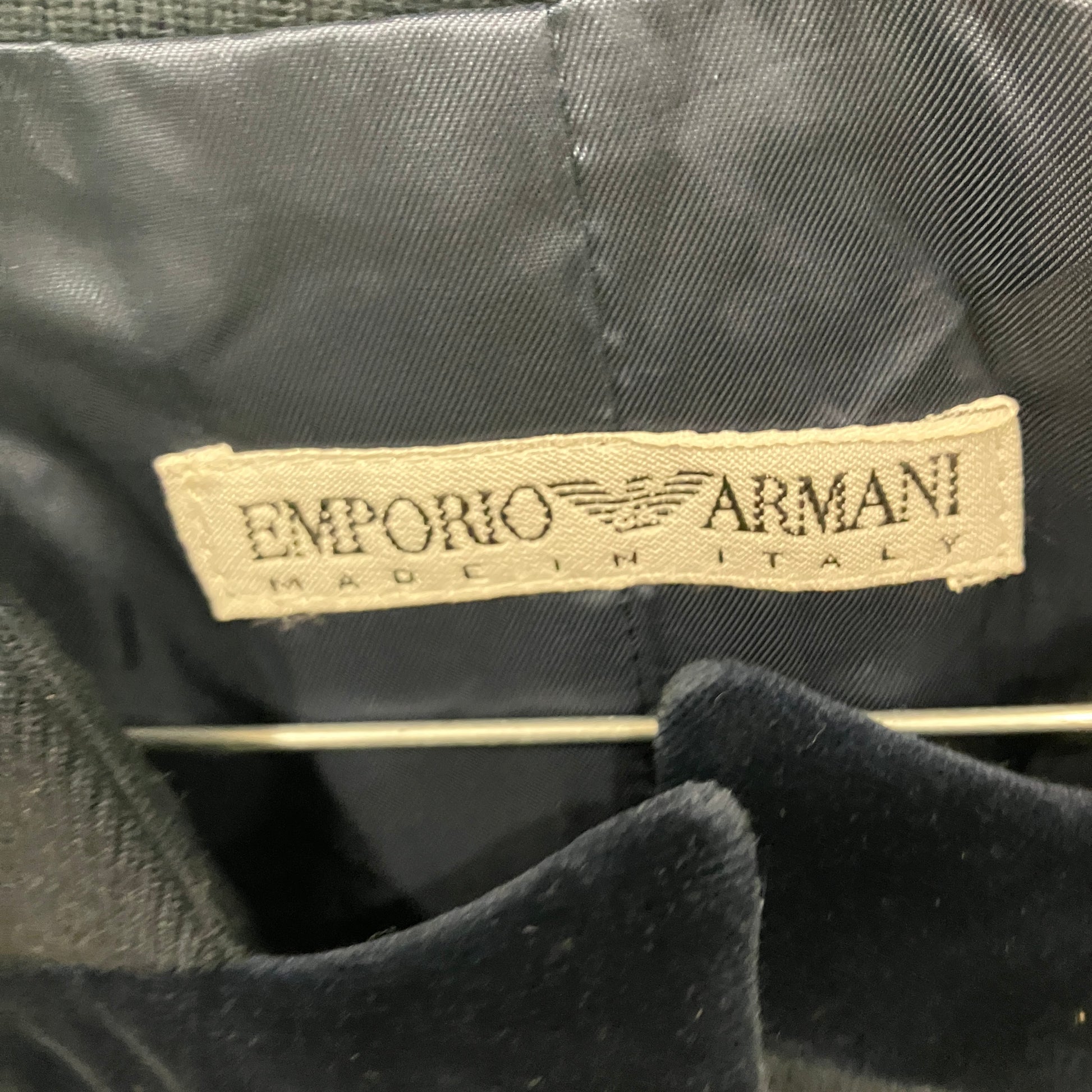 Emporio Armani label on a dark fabric background