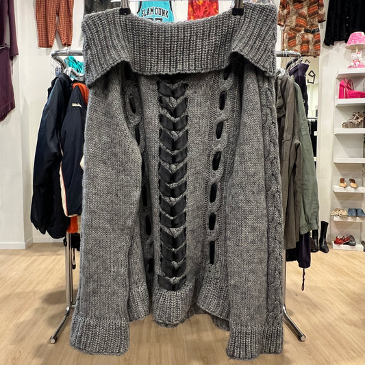 Gray knitted sweater with unique design on a clothing rack in a store