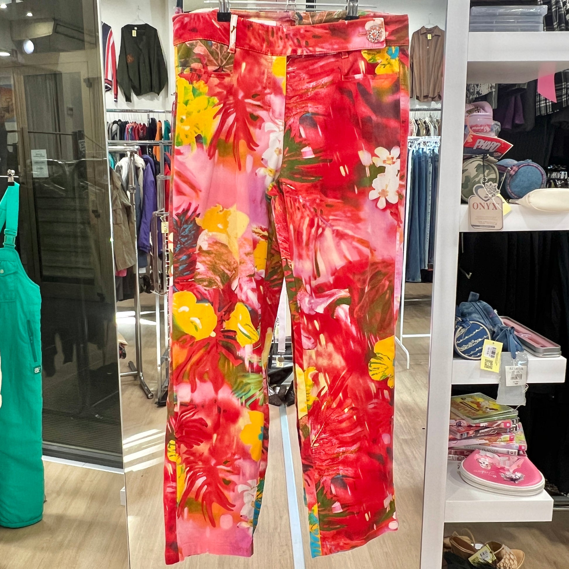 Floral pants hanging in a store with various items in the background