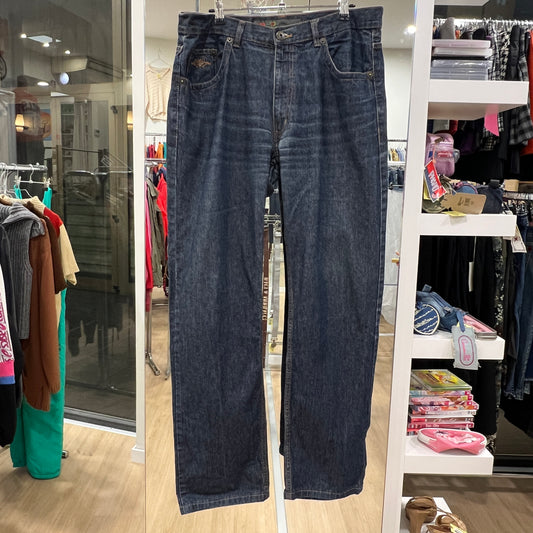 Pair of blue jeans hanging in a store with clothing racks in the background