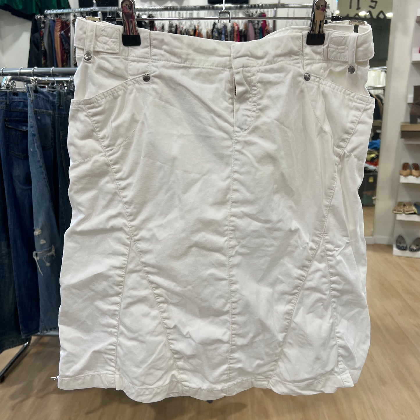 White skirt hanging on a rack in a store setting