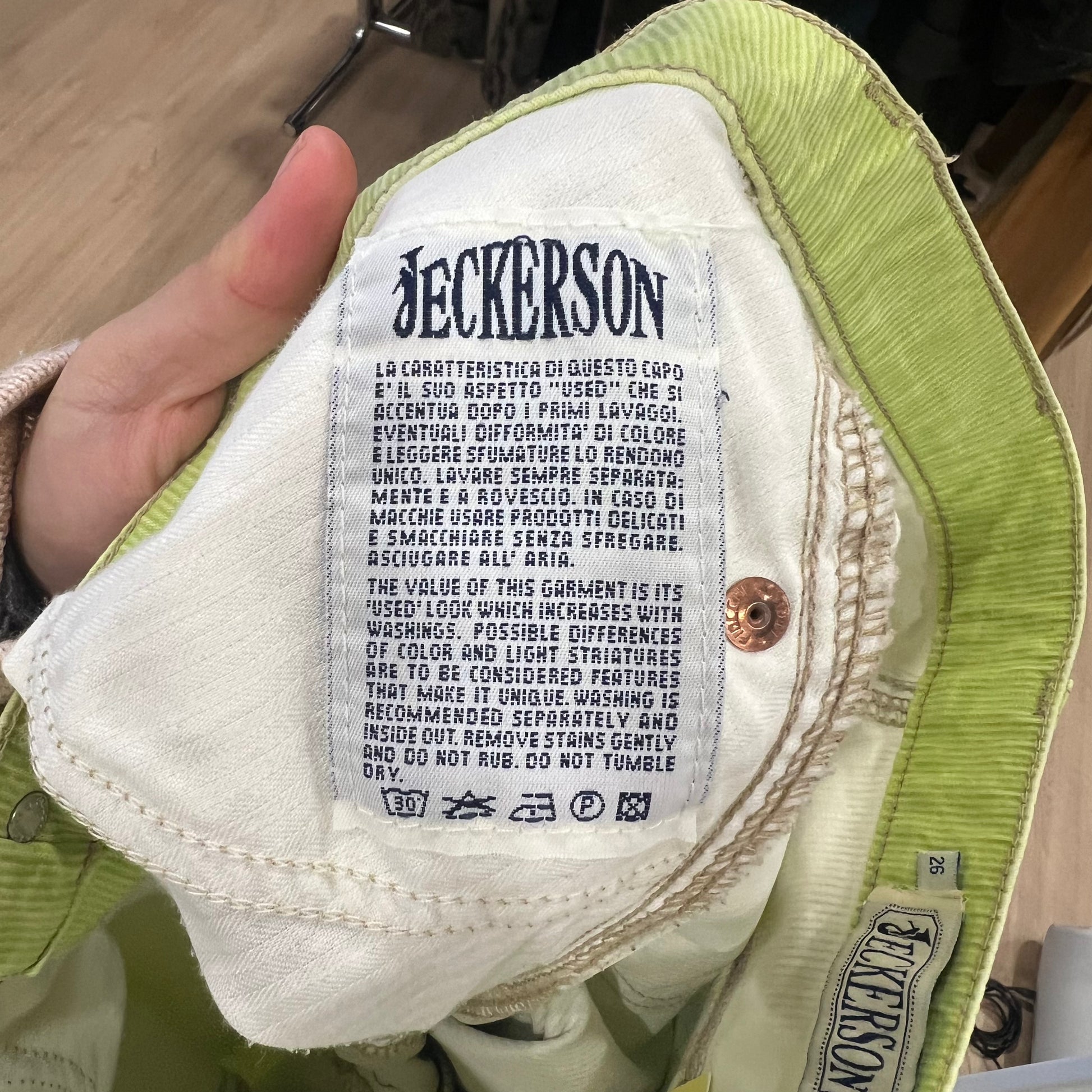 Close-up of a label on a green and white jacket with 'Jeckerson' branding