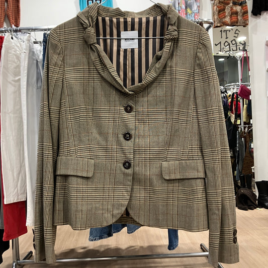 Plaid blazer on a rack with a striped shirt underneath in a store setting