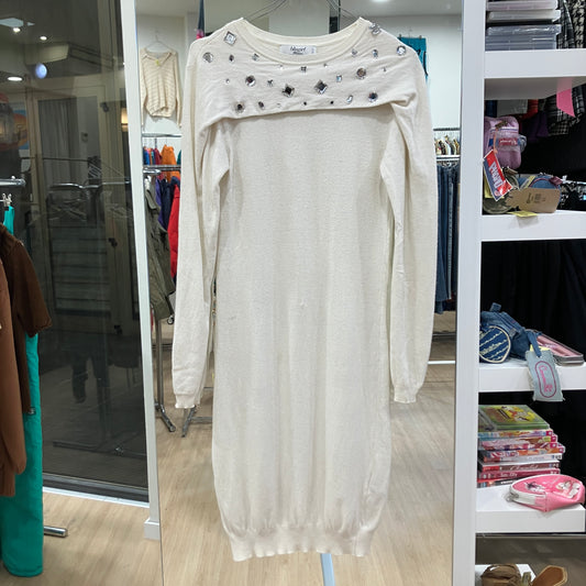 White dress with embellishments on a hanger in a store setting