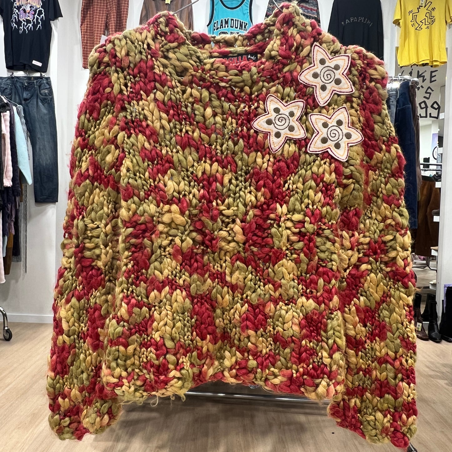 Textured sweater with floral patterns on a rack in a store setting