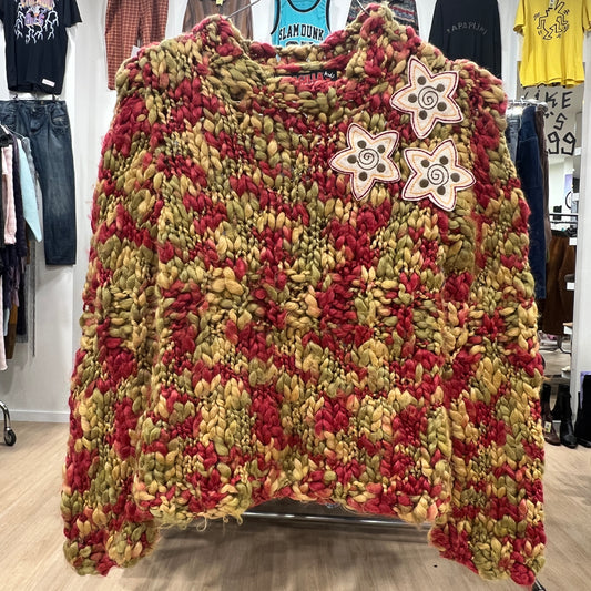 Textured sweater with floral patterns on a rack in a store setting