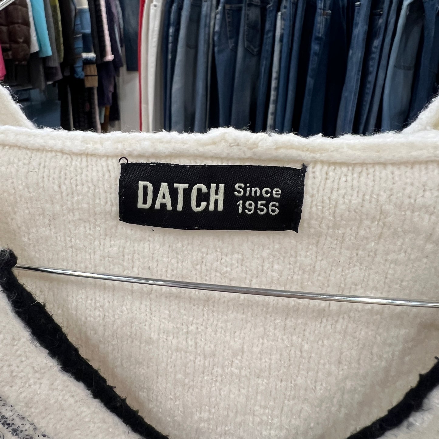 Close-up of a DATCH label on a product with a clothing store background