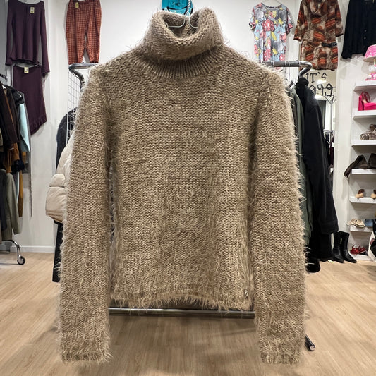 Beige turtleneck sweater on a rack in a clothing store
