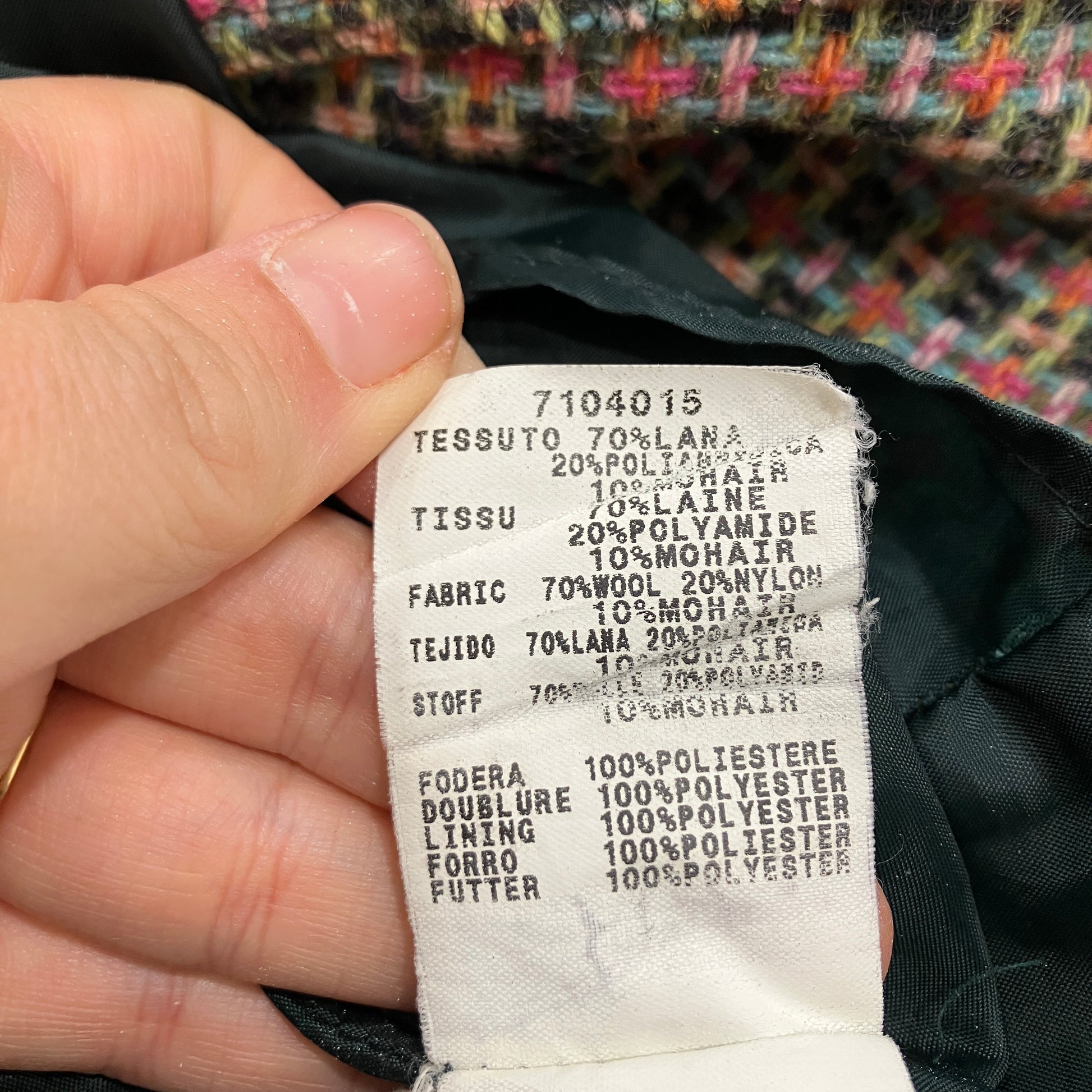 Clothing label with fabric composition details held by a hand