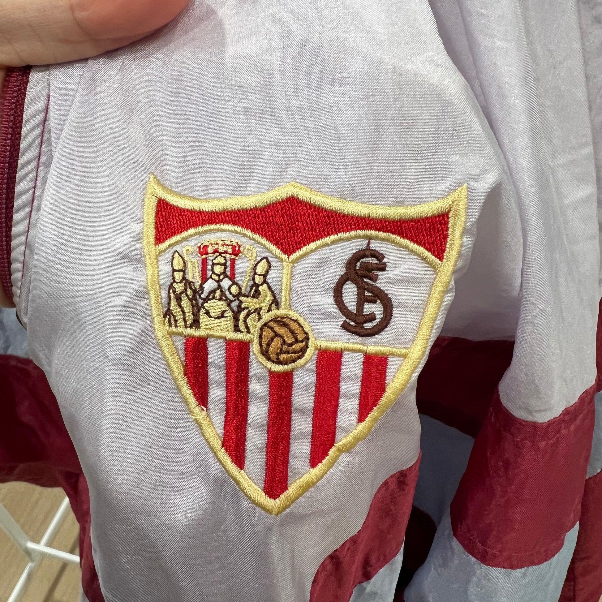 Close-up of a sports team logo patch on a jacket with red and white colors