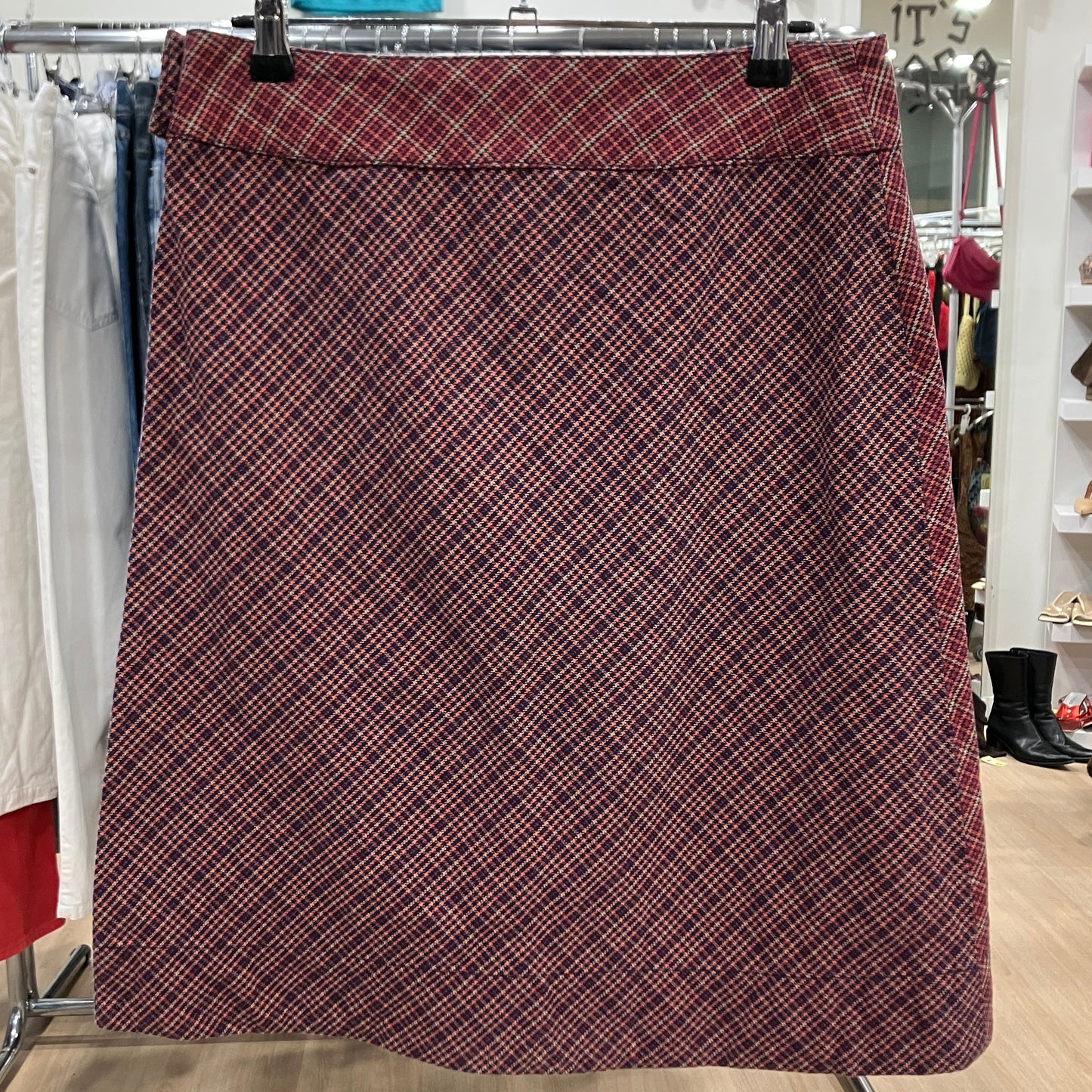 Plaid skirt hanging on a rack in a store setting