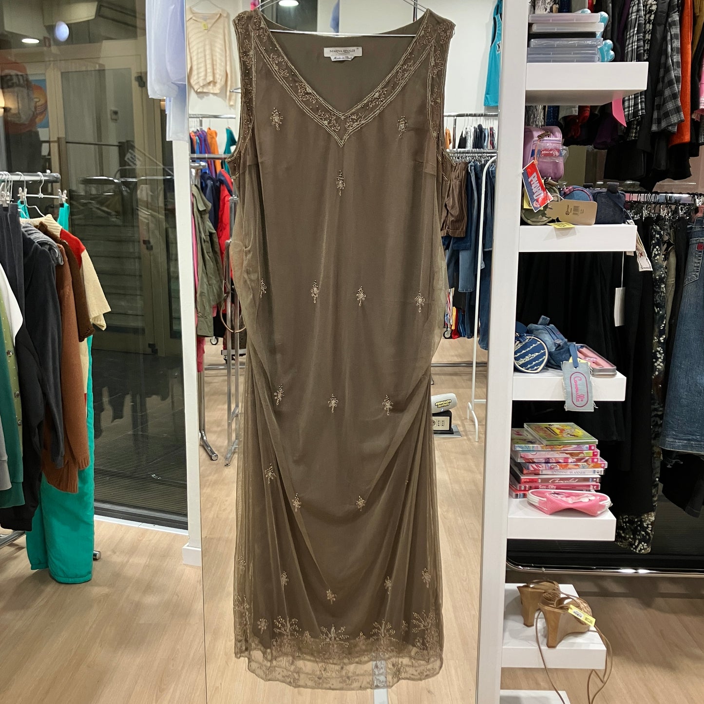 Brown dress with intricate detailing hanging in a store