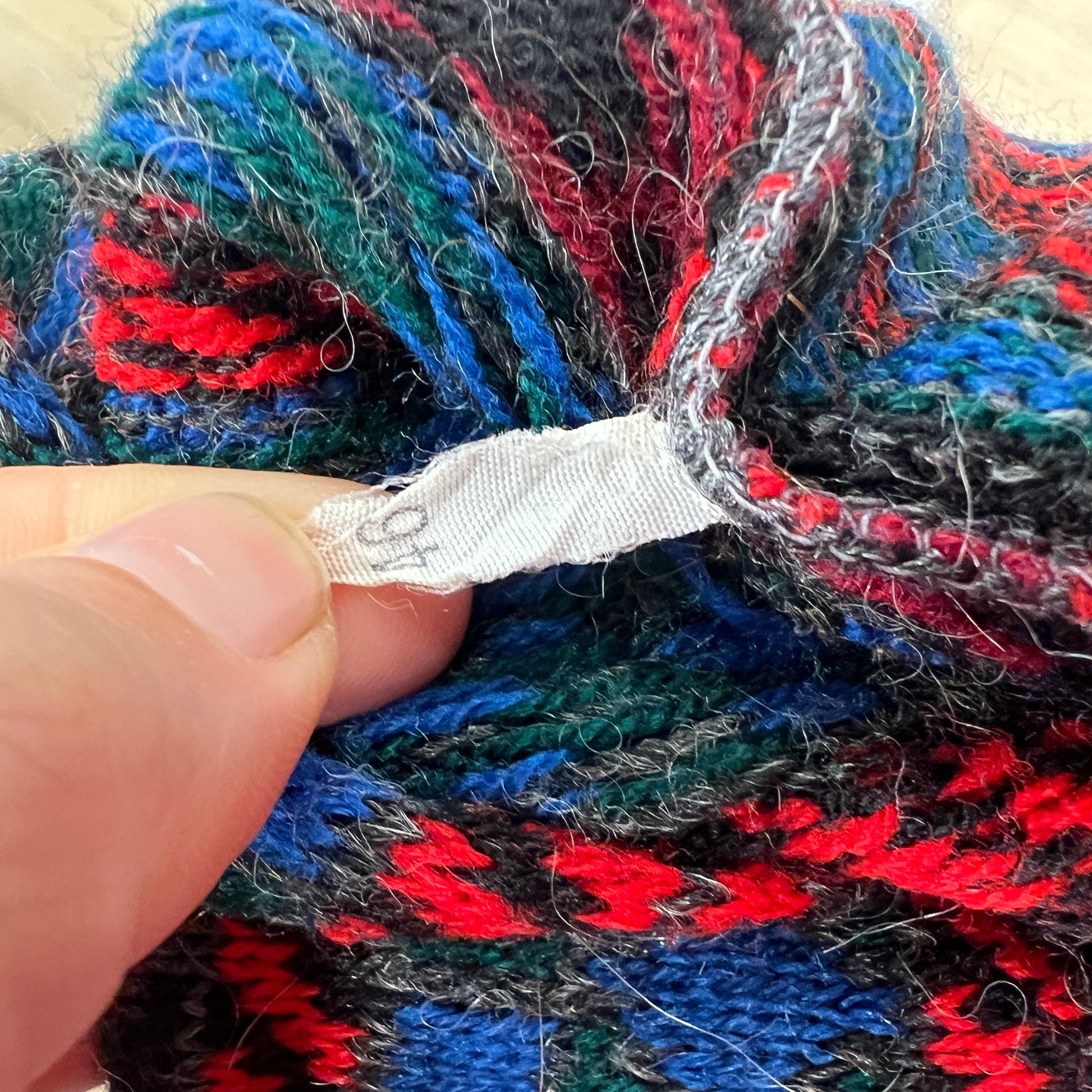 Multicolored yarn with a hand holding a white label