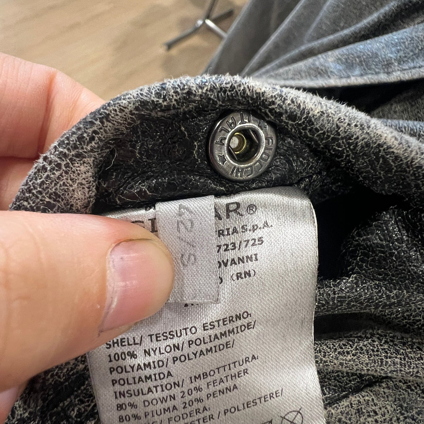 Close-up of a clothing label on a gray fabric background