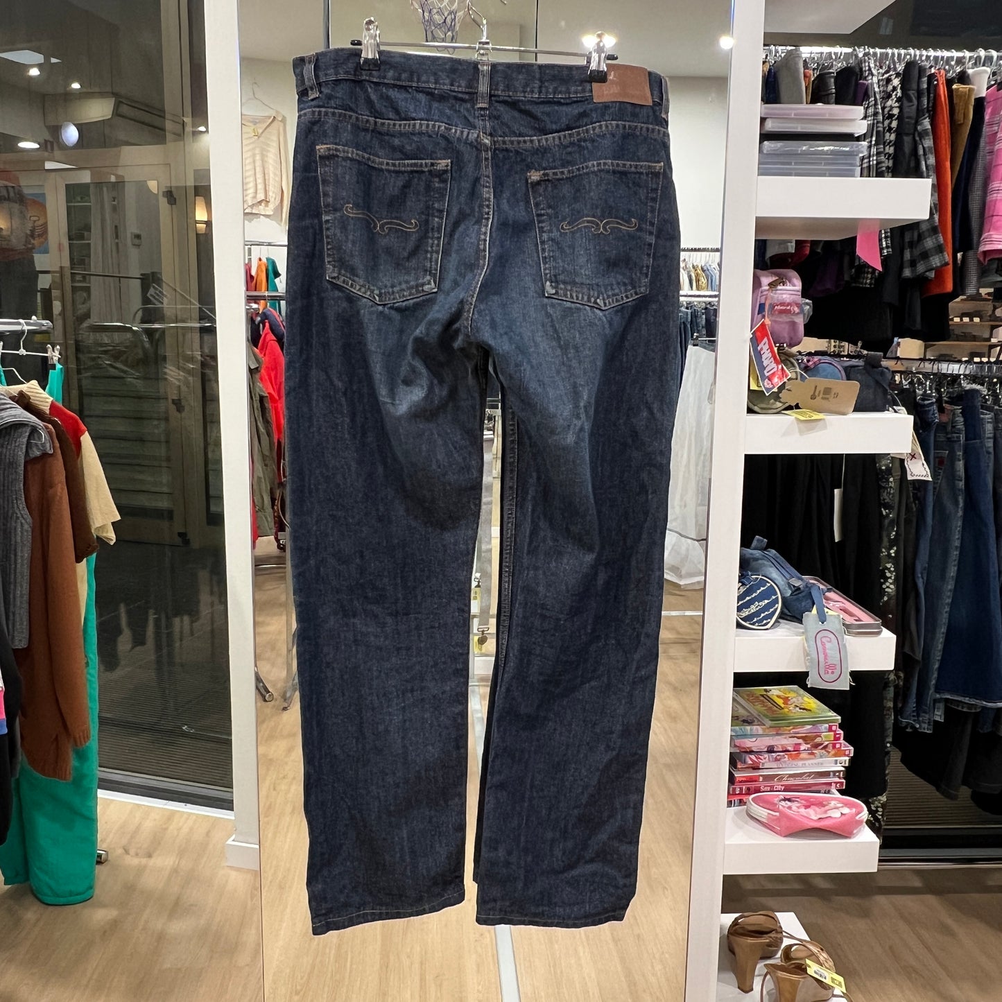 Pair of blue jeans hanging on a rack in a store setting