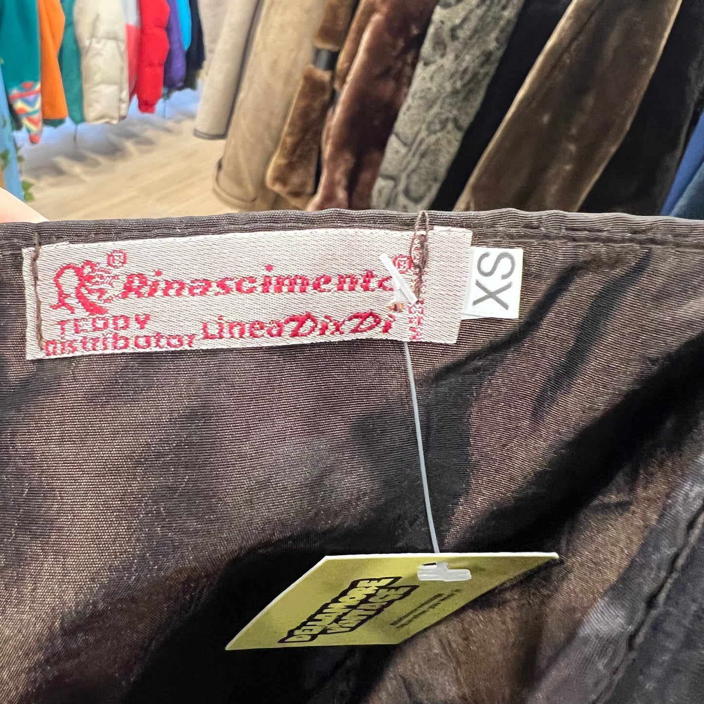 Close-up of a clothing tag with brand name on a garment in a store setting