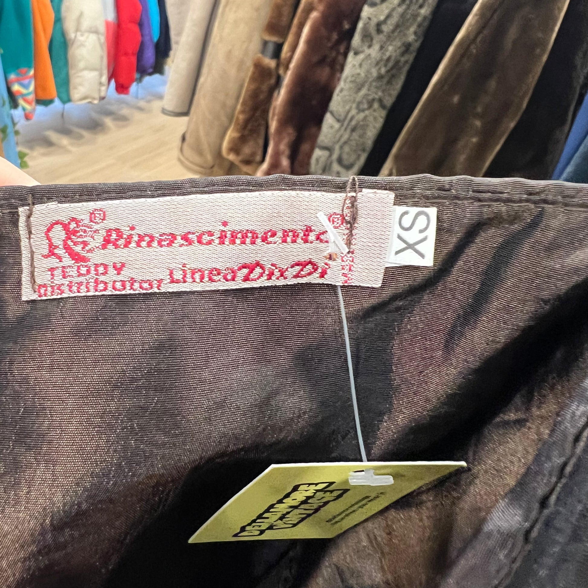 Close-up of a clothing tag with brand name on a garment in a store setting
