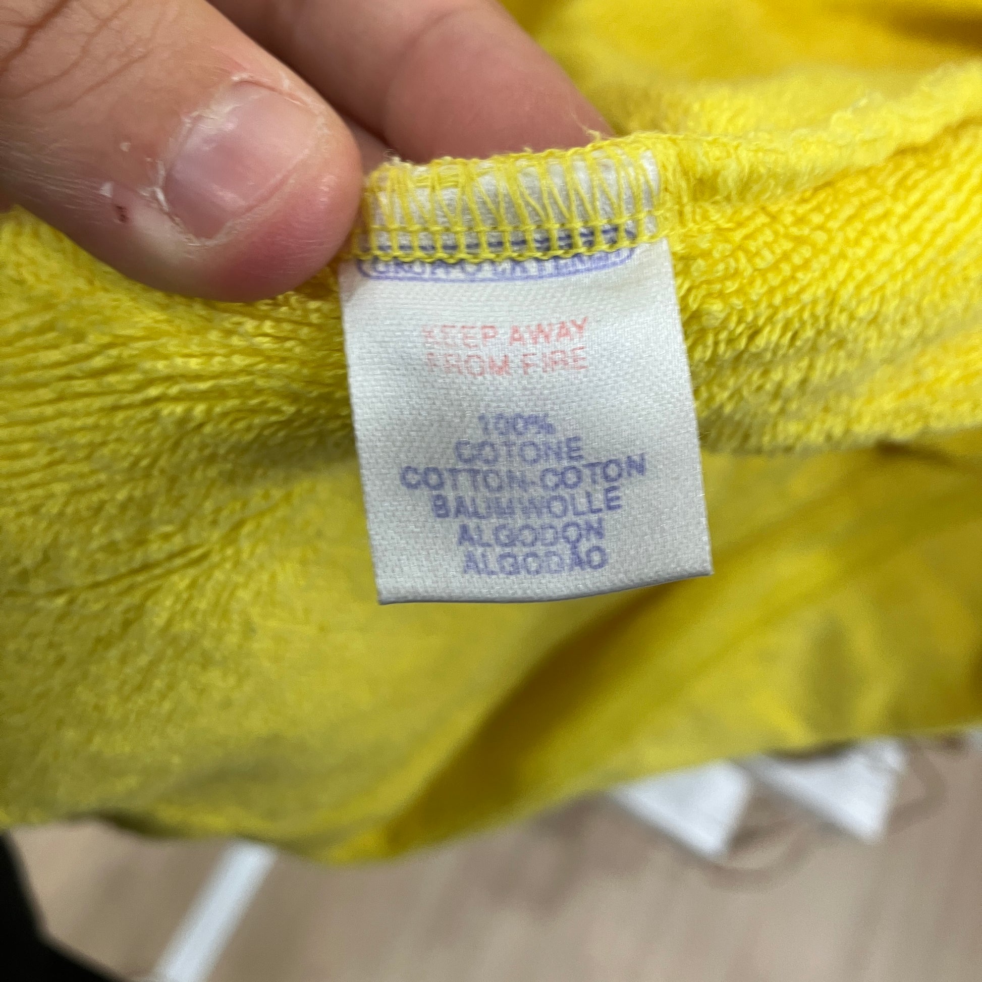 Clothing tag on a yellow fabric with text