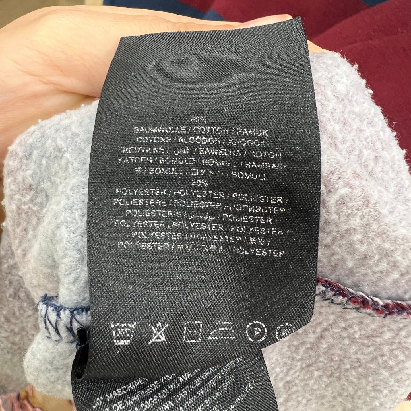 Textile label with material composition and care instructions on a fabric background