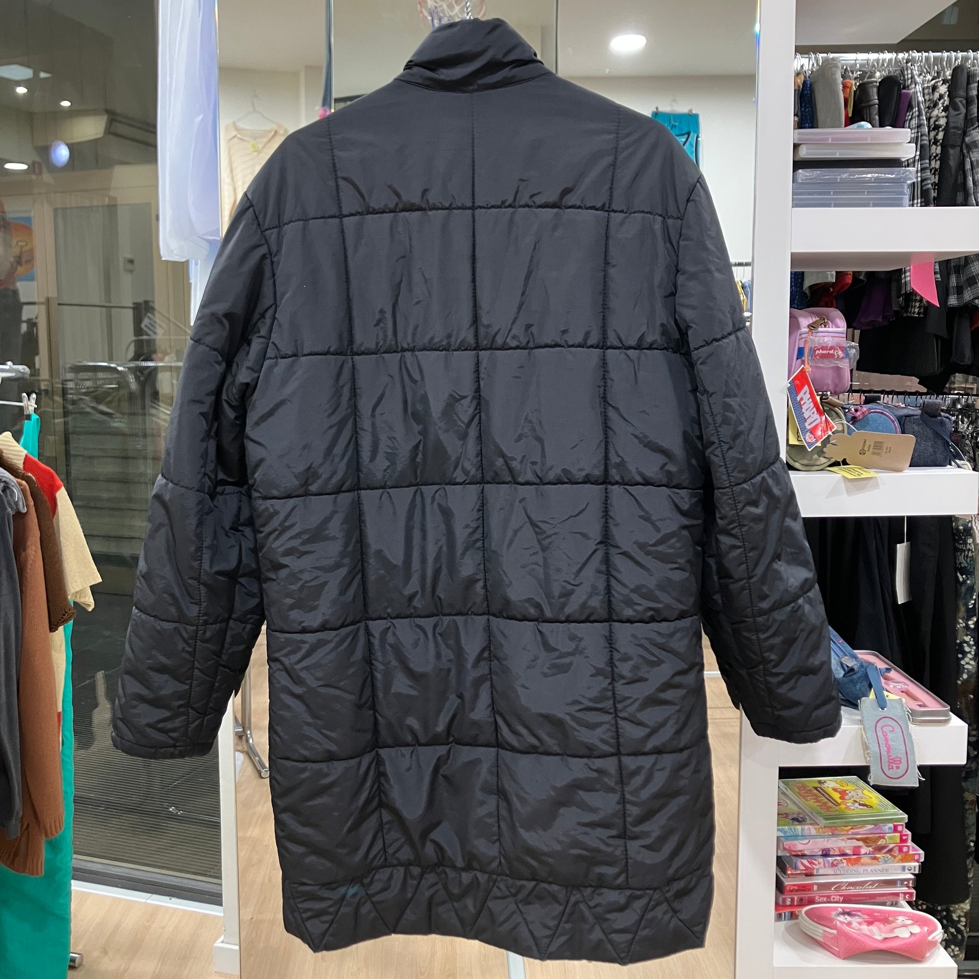Black puffer jacket on a mannequin in a store setting
